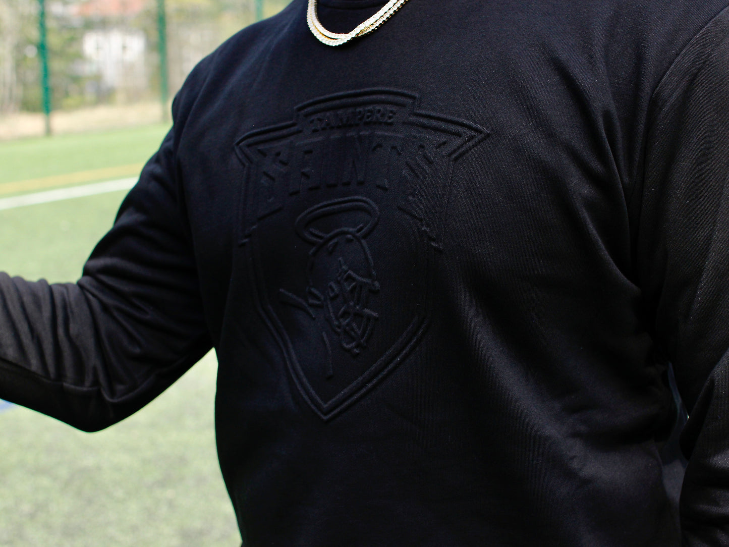 Musta collegepaita Tampere Saints logolla